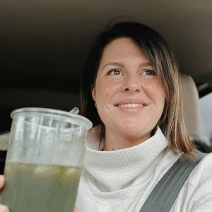 woman hold cup with green liquid in it